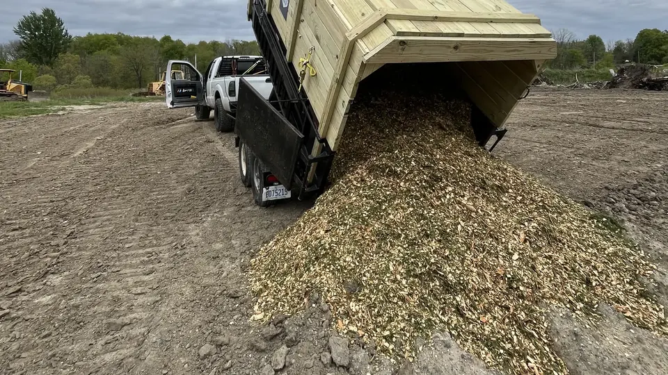 A Mercer Tree Services dump trailer carrying wood chips and tree debris after cleanup